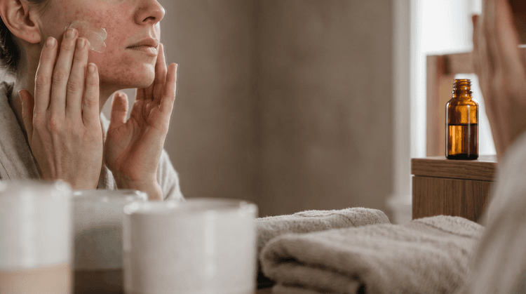 A woman applying cream to her sensitized skin in a bathroom